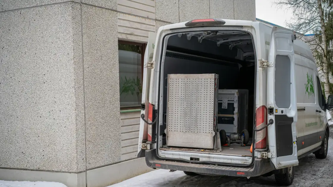 A removal van with its rear doors open on a snowy northern European street