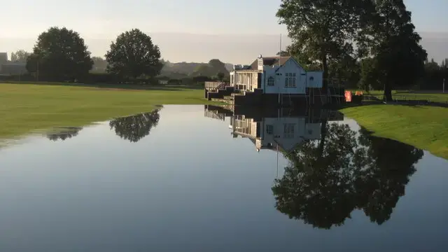 Flood water from the River Severn covering ground beside a sports pavilion in Worcester